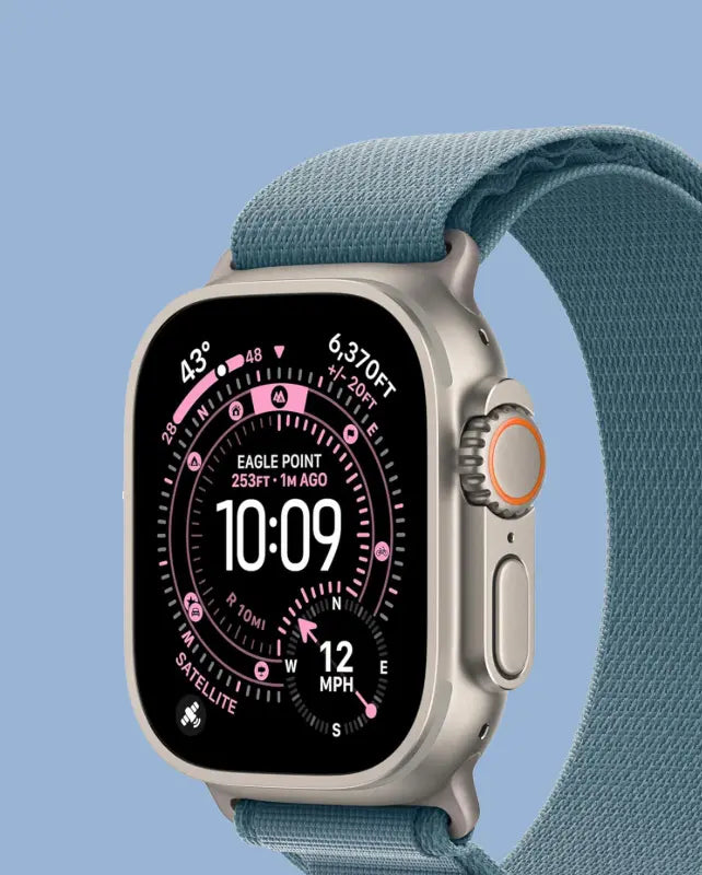 Apple Watch with teal sport loop band displaying compass watchface showing 10:09 time against blue background
